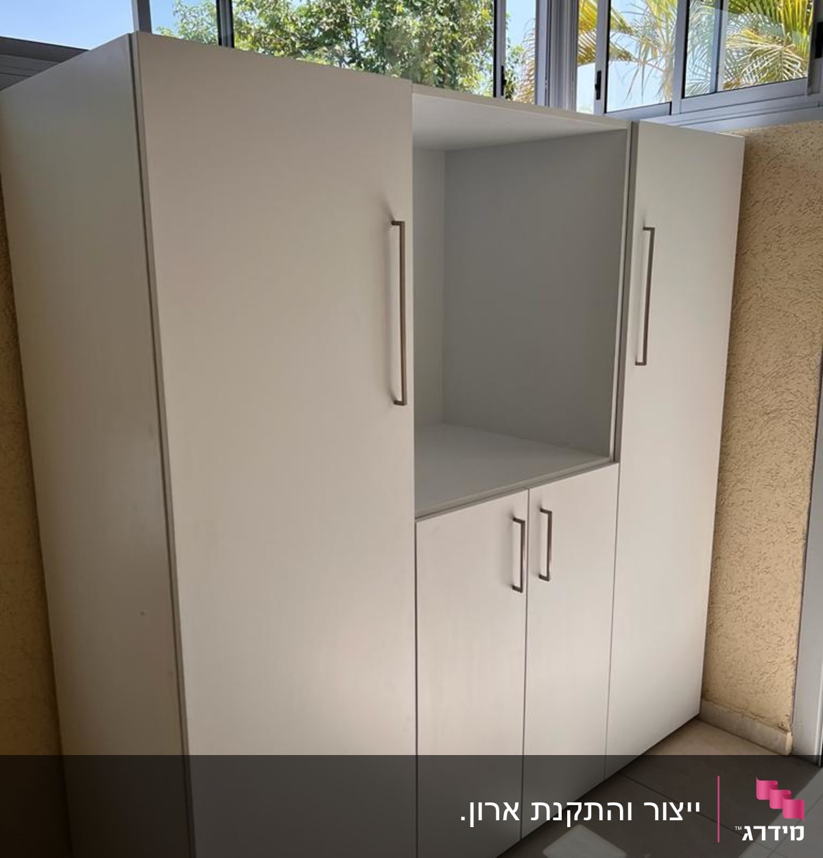 ארון לבן עם ידיות מתכת בחדר מואר